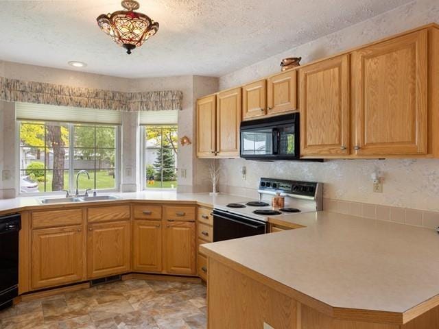 8409 N Pine Meadows Ln, Nine Mile Falls, WA 99026 - kitchen with a sink, light countertops, a textured ceiling, a peninsula, and black appliances