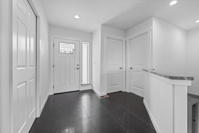 entrance foyer with baseboards and recessed lighting