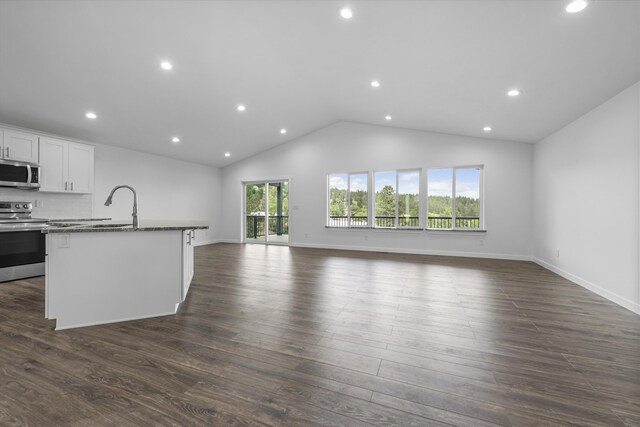 unfurnished living room featuring a sink, recessed lighting, baseboards, lofted ceiling, and dark wood-type flooring