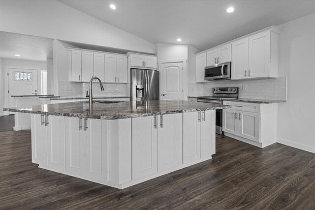 kitchen featuring appliances with stainless steel finishes, a sink, a kitchen island with sink, white cabinetry, and dark wood-style floors