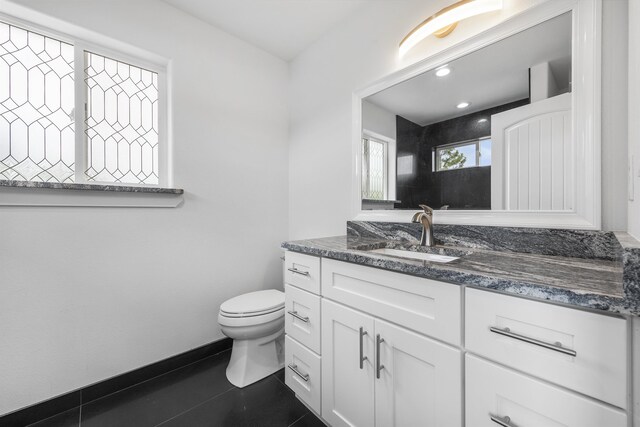 bathroom featuring vanity, tile patterned flooring, toilet, baseboards, and recessed lighting