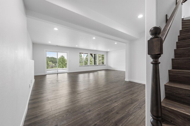 unfurnished living room featuring stairs, recessed lighting, baseboards, and dark wood finished floors