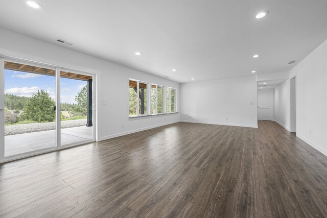 unfurnished living room with dark wood-style flooring, visible vents, and recessed lighting