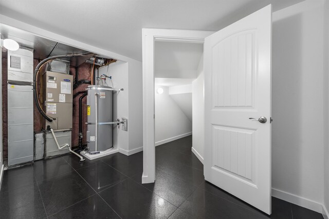 interior space with baseboards and water heater