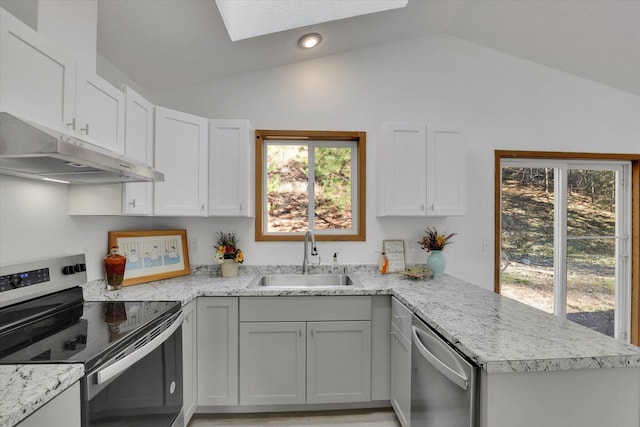 129 E Wynot Dr, Nine Mile Falls, WA 99026 - kitchen featuring a sink, lofted ceiling with skylight, under cabinet range hood, and stainless steel appliances