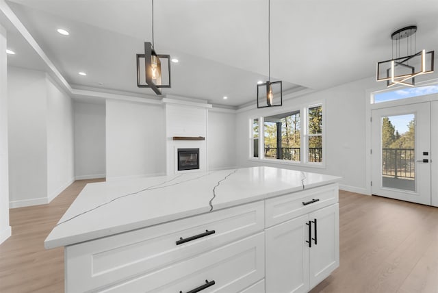 kitchen with baseboards, white cabinets, light wood finished floors, open floor plan, and recessed lighting