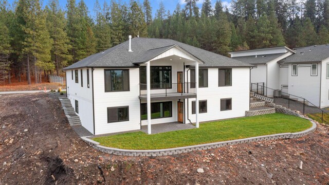 back of house featuring stairs, a yard, a patio area, and a balcony