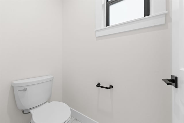 bathroom featuring baseboards and toilet