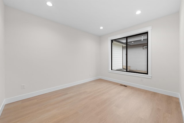 unfurnished room featuring recessed lighting, baseboards, light wood-type flooring, and visible vents