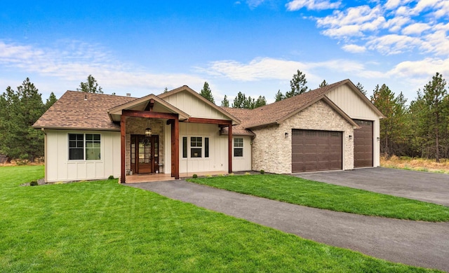 single story home with board and batten siding, driveway, a front yard, and a garage