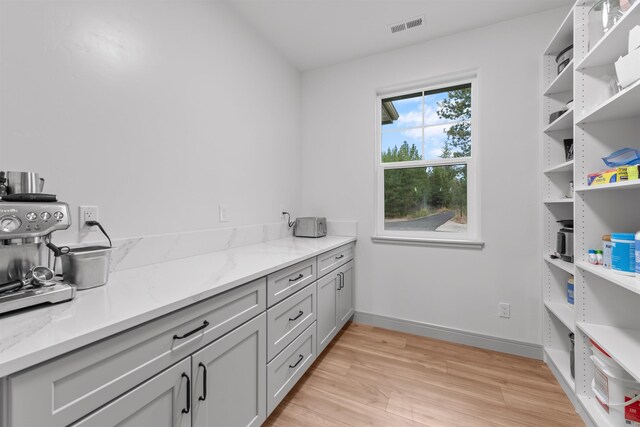 interior space featuring baseboards, visible vents, and light wood-style flooring