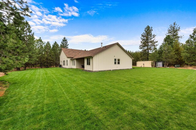 back of house featuring a yard and board and batten siding