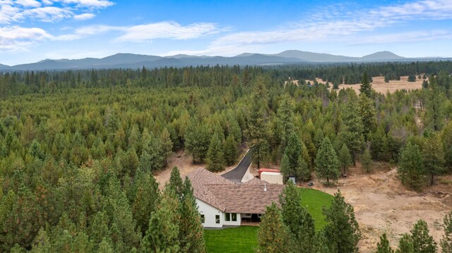 birds eye view of property with a view of trees and a mountain view