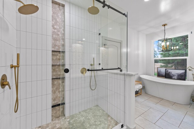 bathroom featuring a walk in shower, a soaking tub, tile patterned floors, and a chandelier