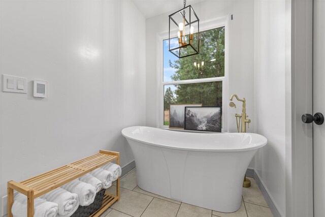 full bath with a freestanding tub, baseboards, and tile patterned flooring