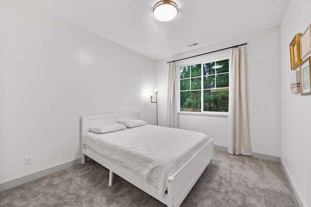 bedroom with visible vents, carpet flooring, and baseboards