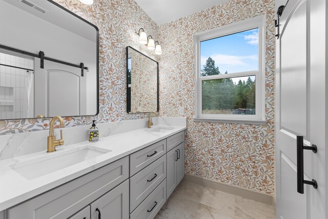 full bath with a sink, wallpapered walls, and visible vents