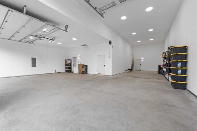 garage with recessed lighting, visible vents, a garage door opener, and electric panel