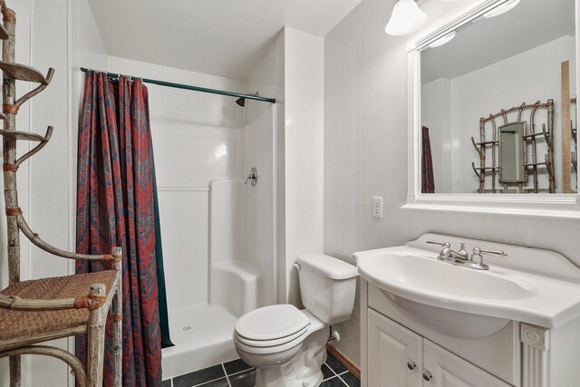 bathroom with vanity, tile patterned flooring, a shower stall, and toilet