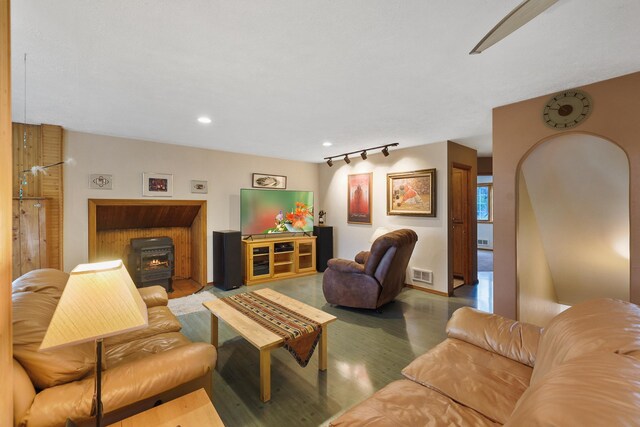 living area featuring visible vents, a wood stove, rail lighting, wood finished floors, and recessed lighting