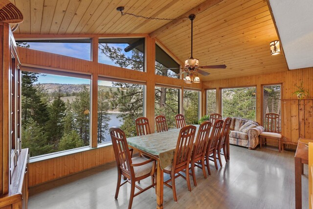 sunroom with wooden walls, vaulted ceiling with beams, wooden ceiling, and wood finished floors