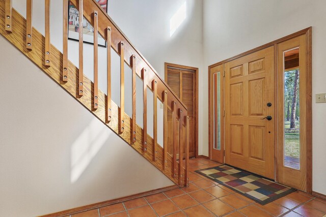 foyer featuring stairway, tile patterned floors, and baseboards
