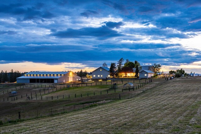 view of property's community with fence, a lawn, and a rural view