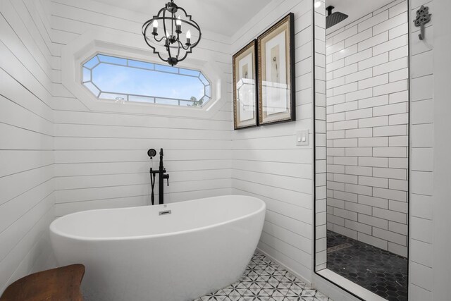 full bathroom featuring an inviting chandelier, a freestanding tub, and walk in shower