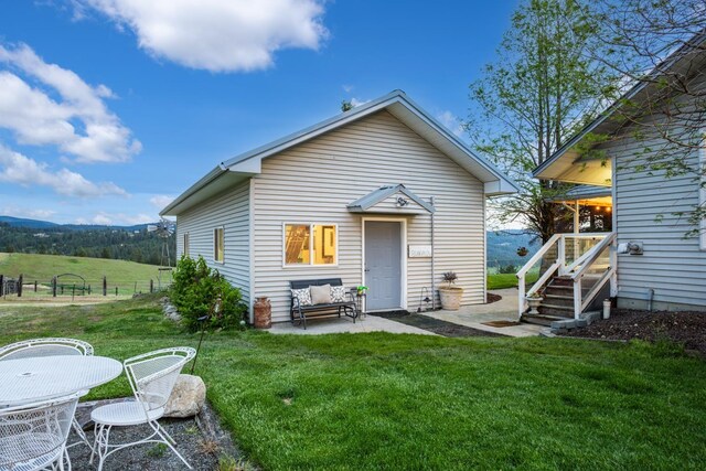 rear view of property with fence, a patio, and a yard