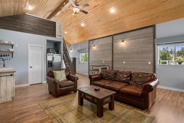 living area with baseboards, high vaulted ceiling, ceiling fan, and wood ceiling