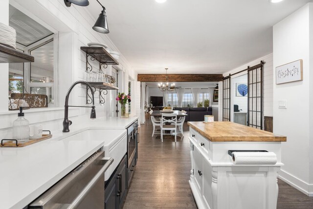 kitchen with wooden counters, open shelves, open floor plan, an inviting chandelier, and dark wood-type flooring