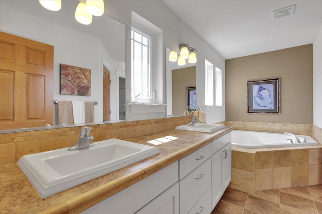 full bathroom featuring visible vents, a sink, a bath, and double vanity