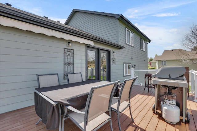 wooden terrace with outdoor dining area and grilling area