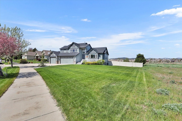 view of front of property with a garage, a front lawn, fence, and concrete driveway