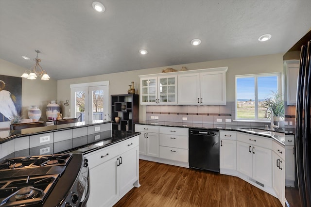 kitchen featuring dark countertops, a sink, dishwasher, visible vents, and range with gas cooktop