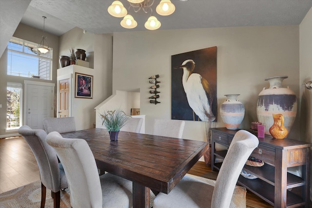 dining space with wood finished floors and a chandelier