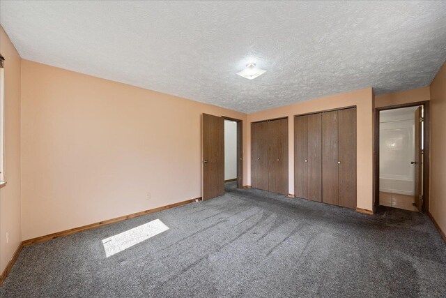 unfurnished bedroom featuring multiple closets, baseboards, and carpet