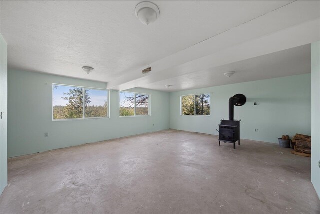 interior space with a wood stove, concrete floors, and a wealth of natural light