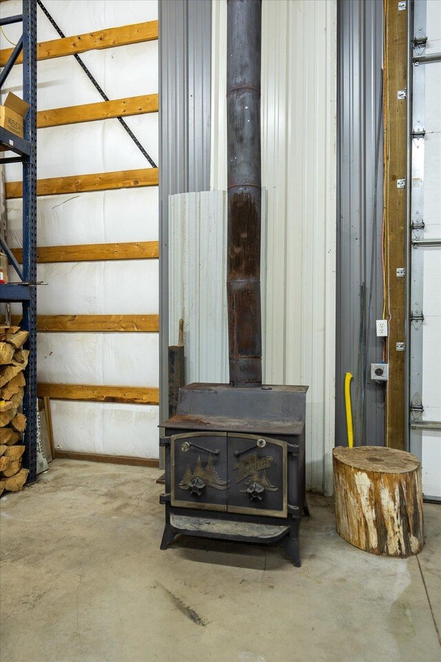 interior space with concrete flooring and a wood stove
