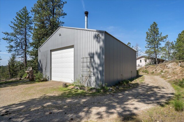 view of outbuilding featuring driveway and an outbuilding