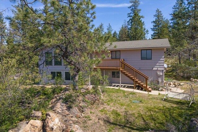 back of property with a wooden deck and stairway
