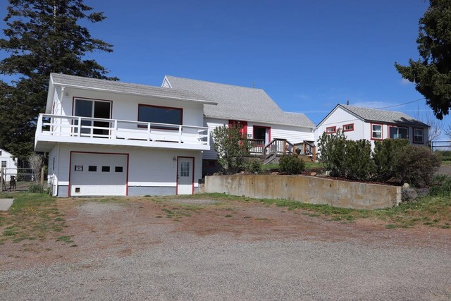 view of front of house with an attached garage and dirt driveway