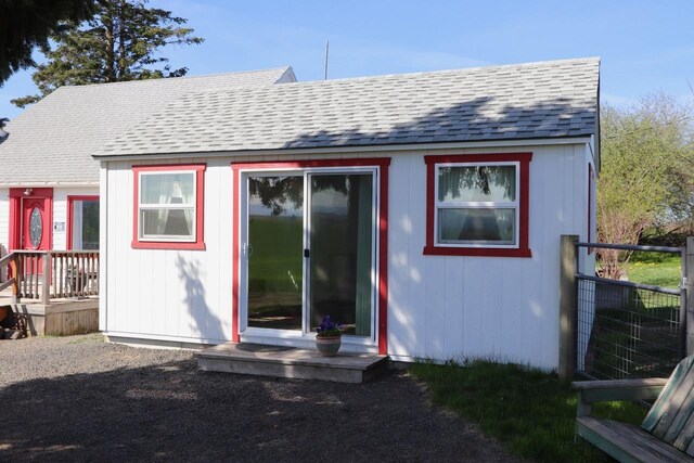 rear view of house with roof with shingles
