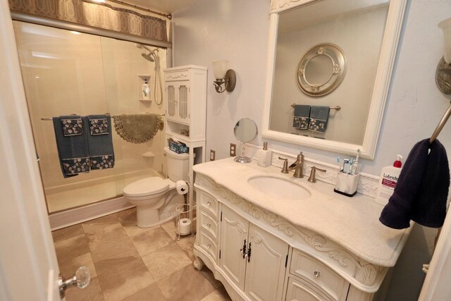 bathroom with vanity, toilet, and a stall shower