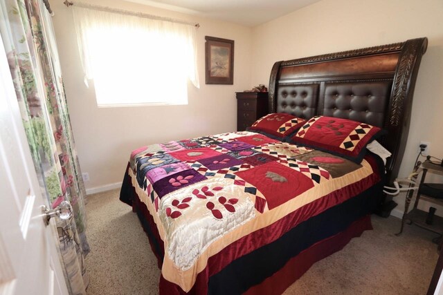 carpeted bedroom featuring baseboards