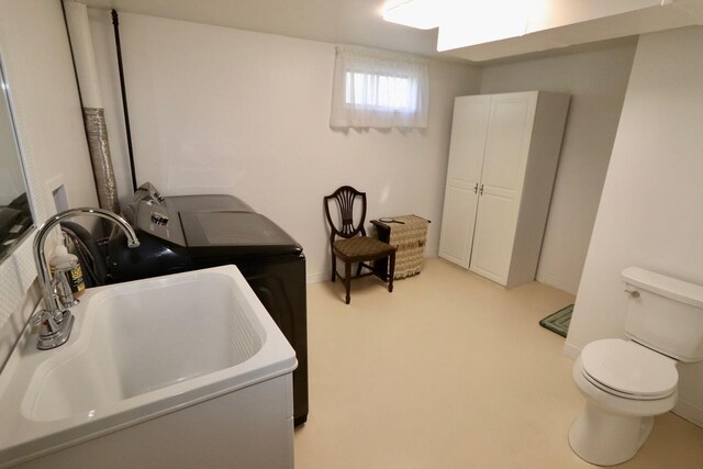 laundry area featuring laundry area, a sink, baseboards, and washing machine and clothes dryer