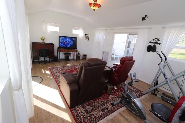 living area with wood finished floors and lofted ceiling