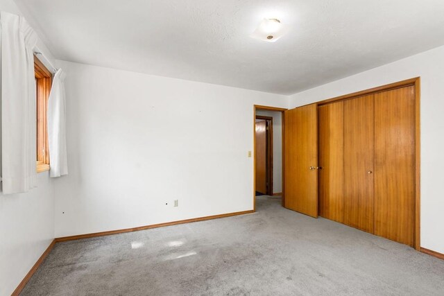 unfurnished bedroom with baseboards and carpet