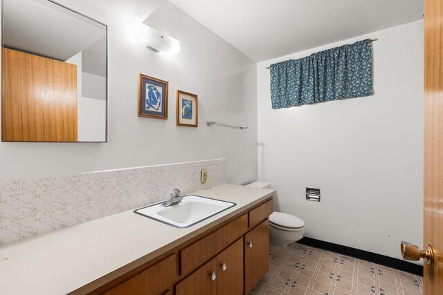 bathroom with backsplash, toilet, tile patterned floors, and vanity