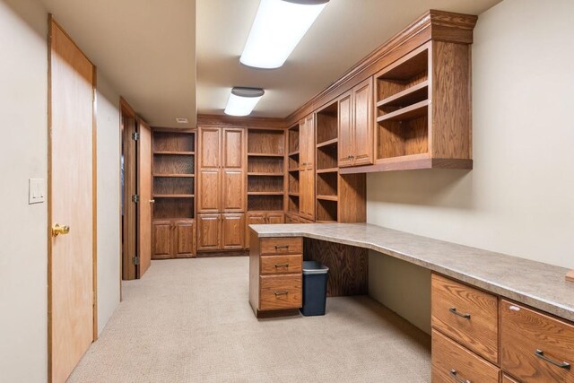 unfurnished office with built in study area and light colored carpet